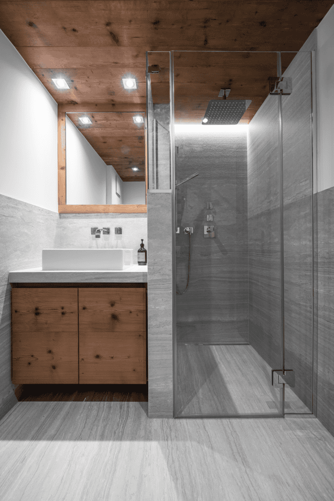Salle de bain en céramique grand format avec assemblages à 45° et finitions de marbrier réalisés par Unique Onyx en Suisse.